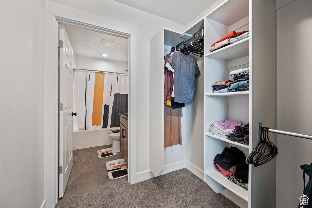 Walk in closet featuring dark colored carpet