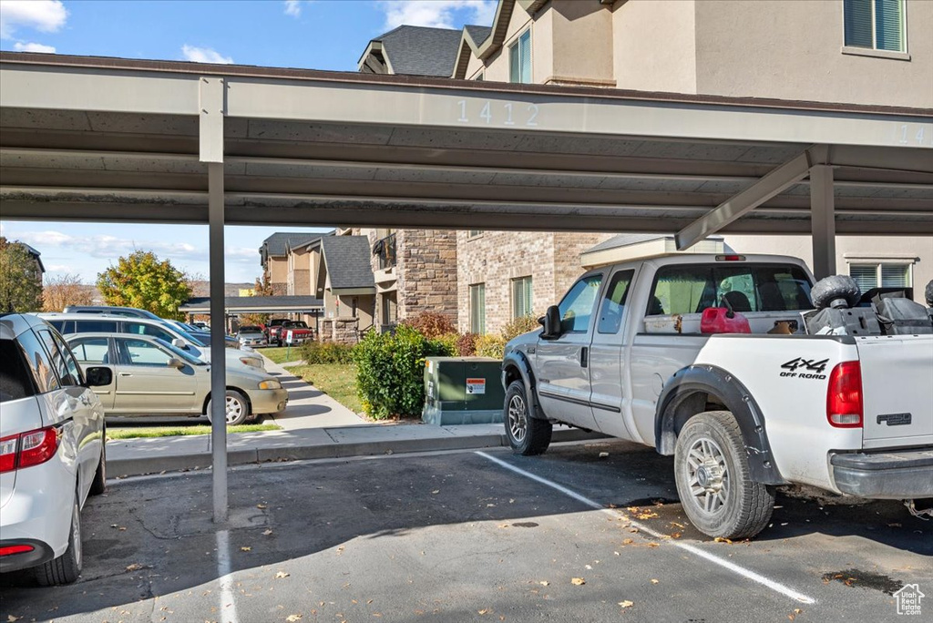 View of parking / parking lot featuring a carport