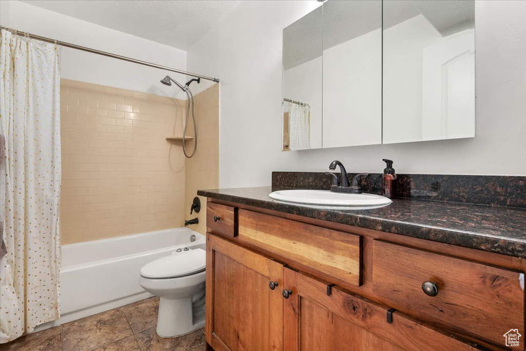 Full bathroom with shower / bath combo, vanity, and toilet