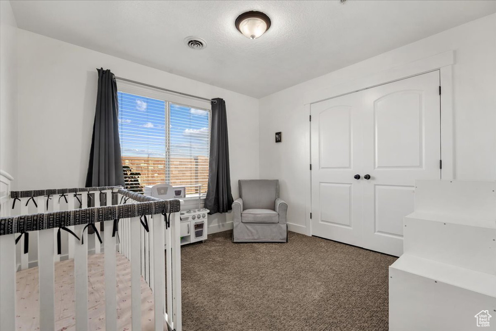 Bedroom featuring dark colored carpet and a closet