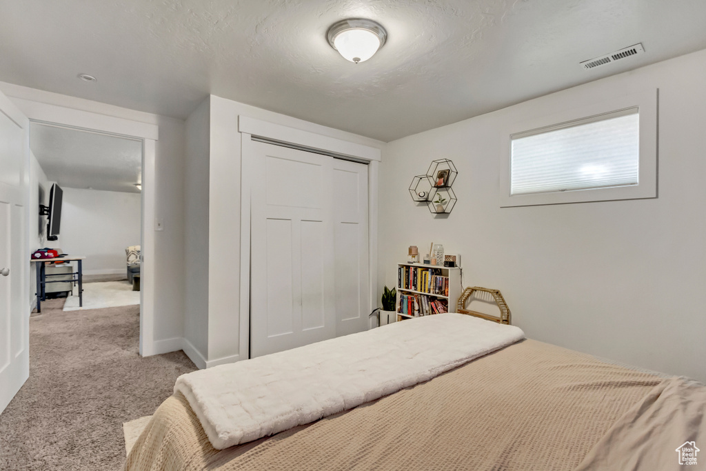 Carpeted bedroom featuring a closet