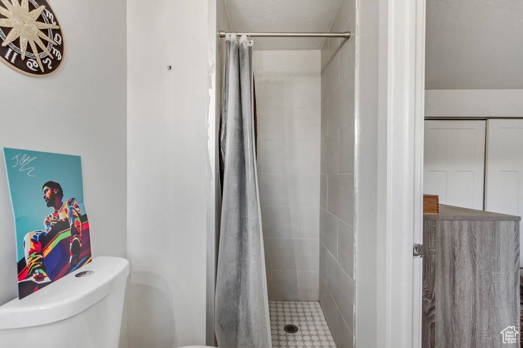 Bathroom featuring toilet and a shower with shower curtain