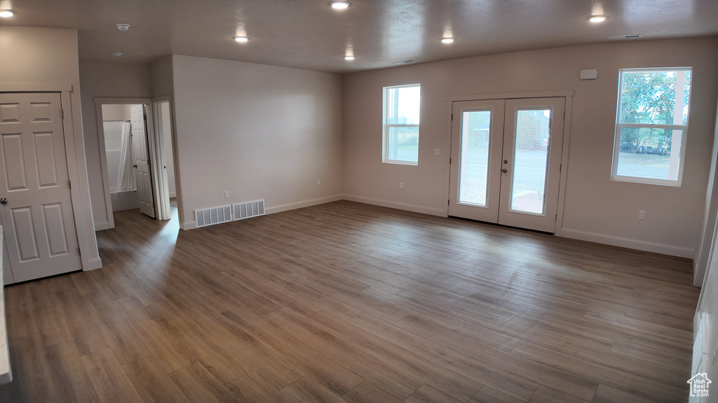 Unfurnished room featuring a wealth of natural light, hardwood / wood-style floors, and french doors