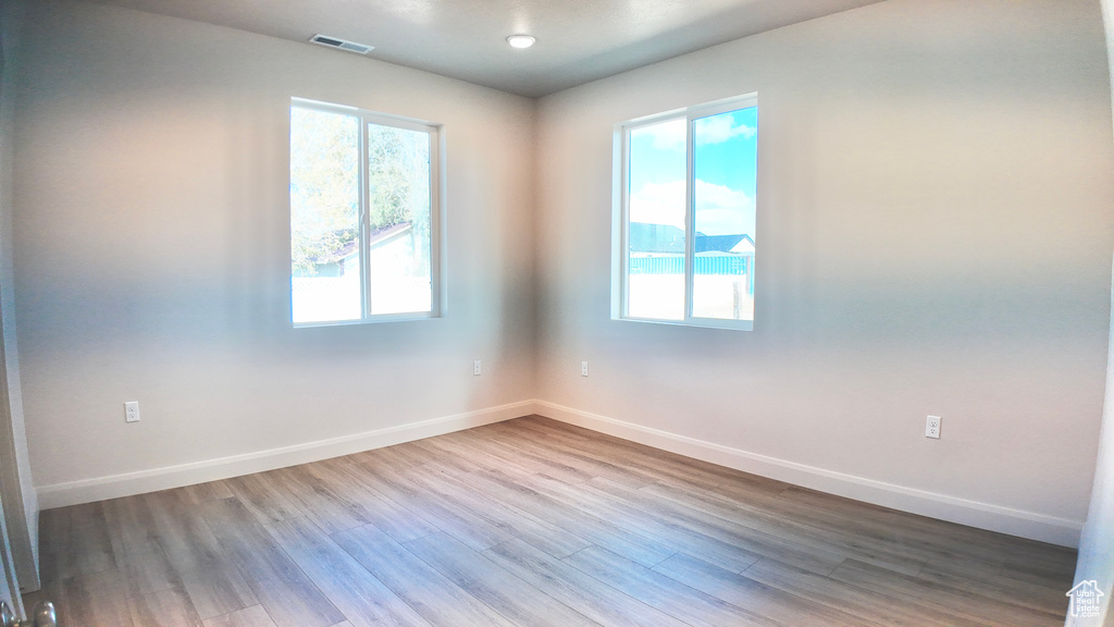 Unfurnished room featuring a wealth of natural light and hardwood / wood-style flooring