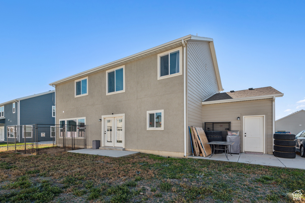 Back of house with a lawn, french doors, and a patio area