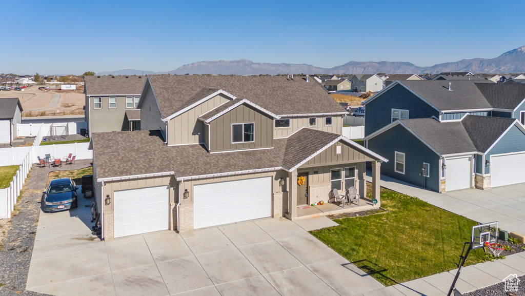 View of front of property featuring a mountain view, a garage, and a front lawn