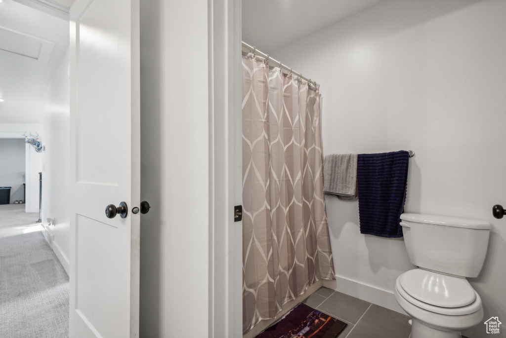 Bathroom featuring tile patterned flooring, toilet, and a shower with curtain