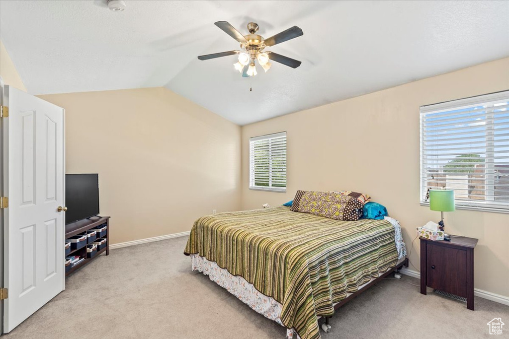 Bedroom with light carpet, baseboards, lofted ceiling, and ceiling fan
