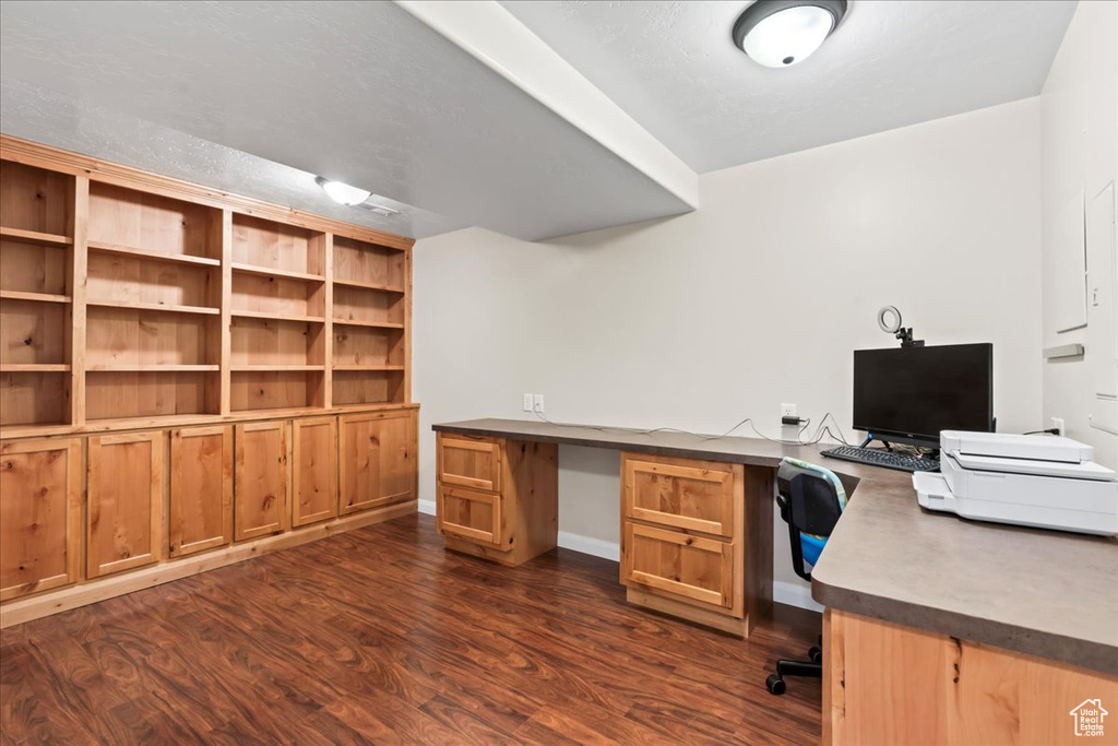 Unfurnished office with dark wood-type flooring and built in desk