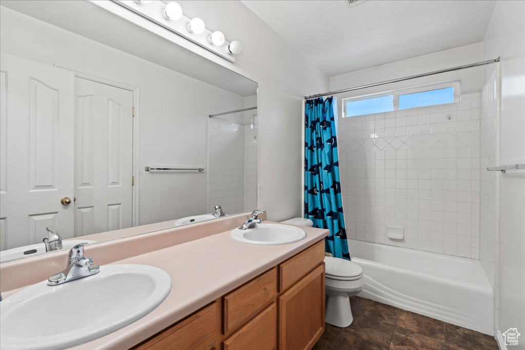 Full bathroom featuring shower / tub combo with curtain, vanity, and toilet