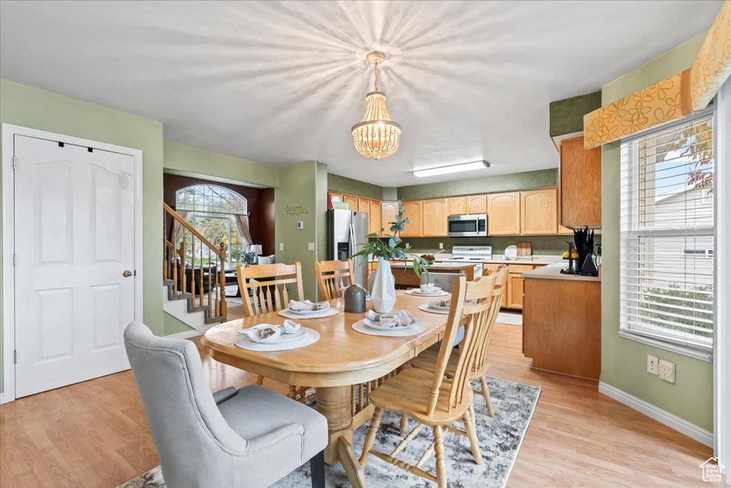 Dining space featuring light hardwood / wood-style floors, plenty of natural light, and a notable chandelier