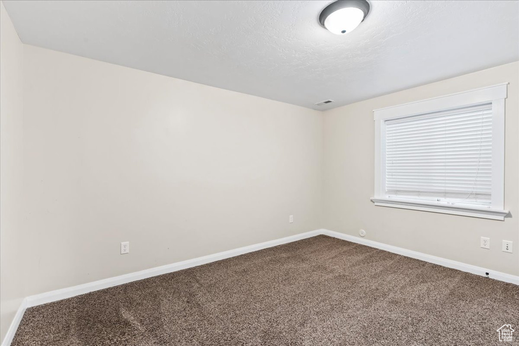 Carpeted empty room with a textured ceiling