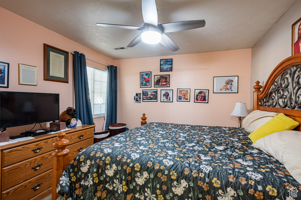 Bedroom with ceiling fan and a textured ceiling