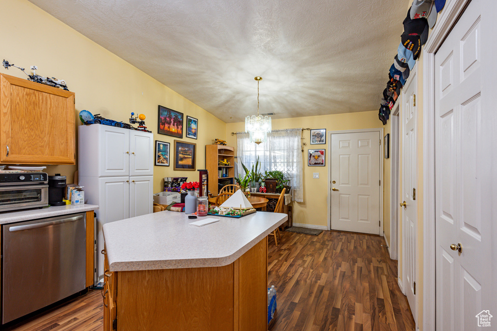 Kitchen featuring a kitchen island, dark hardwood / wood-style flooring, hanging light fixtures, an inviting chandelier, and dishwasher