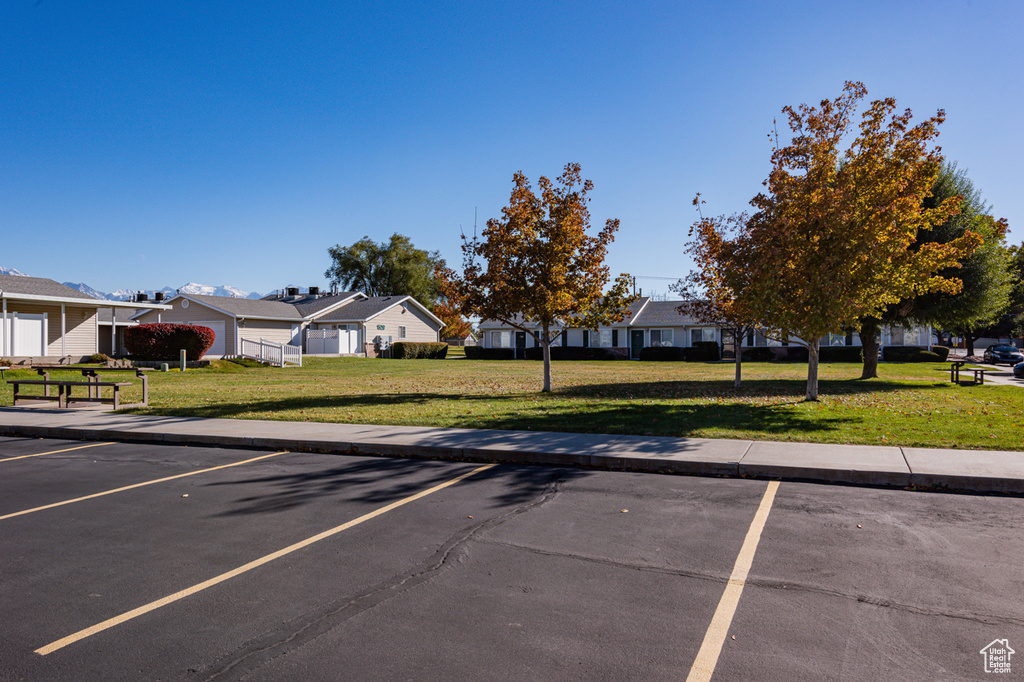 View of vehicle parking featuring a lawn