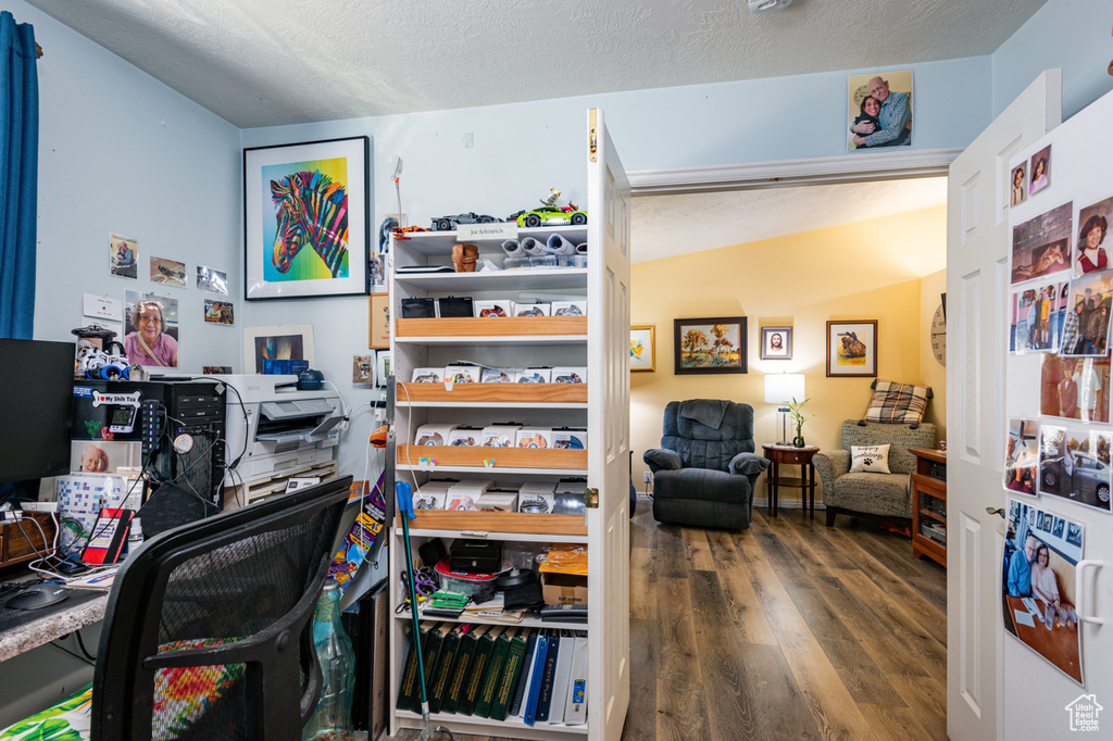 Home office featuring hardwood / wood-style flooring, a textured ceiling, and lofted ceiling