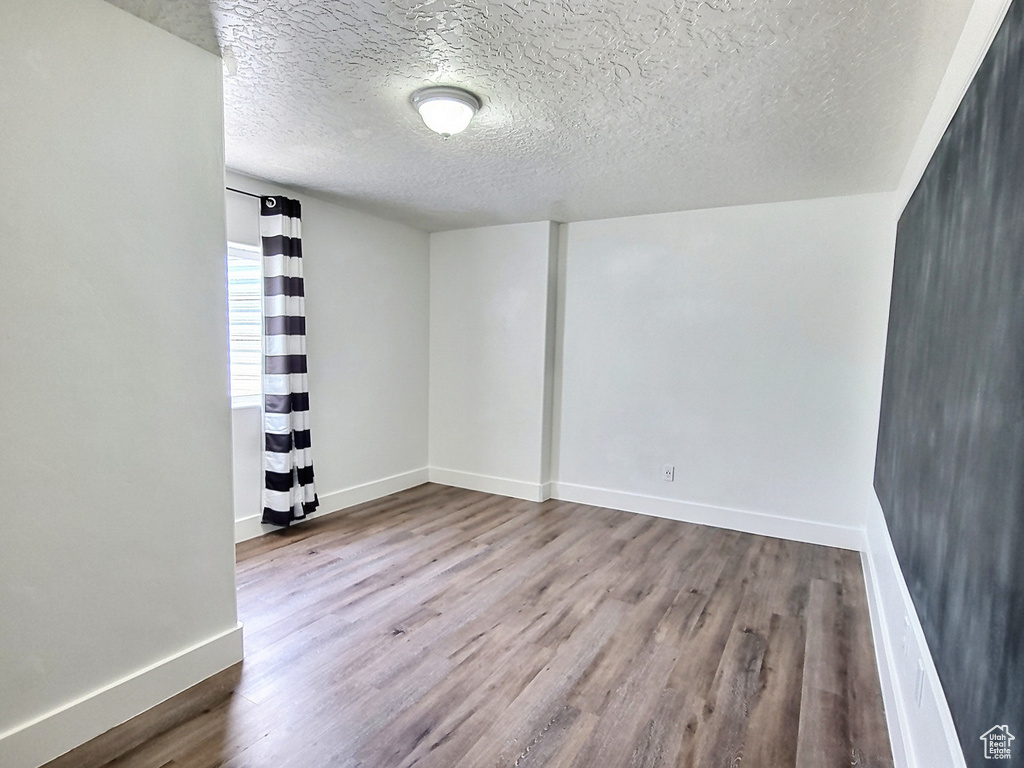 Spare room featuring hardwood / wood-style floors and a textured ceiling