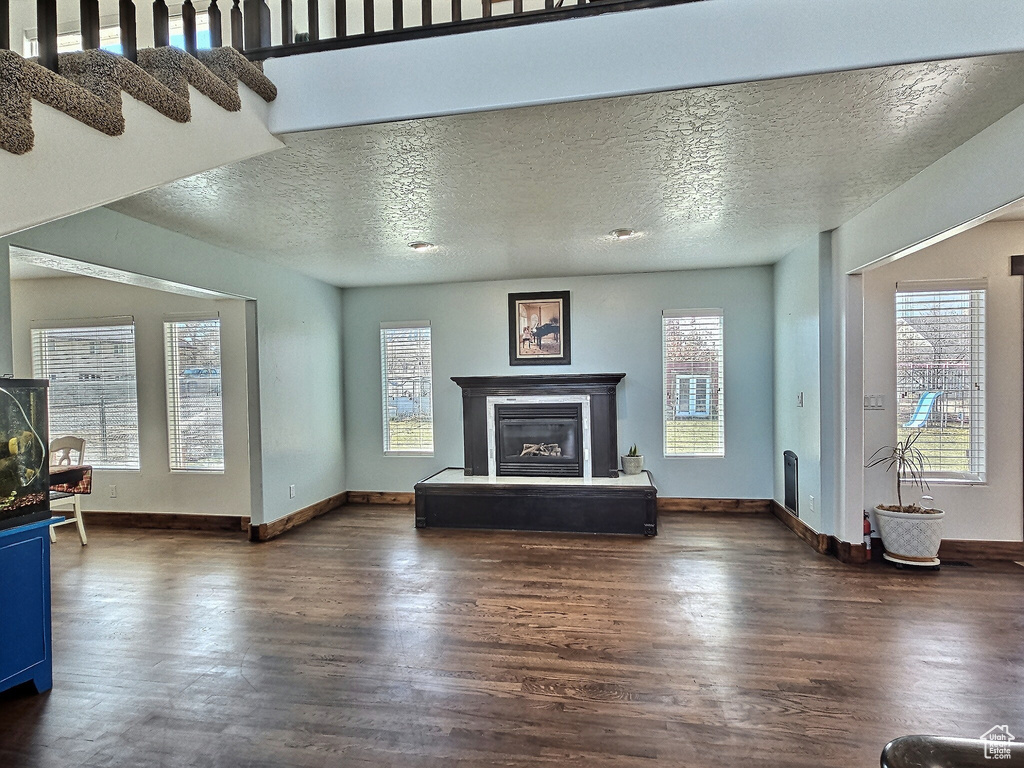 Unfurnished living room featuring a textured ceiling and plenty of natural light