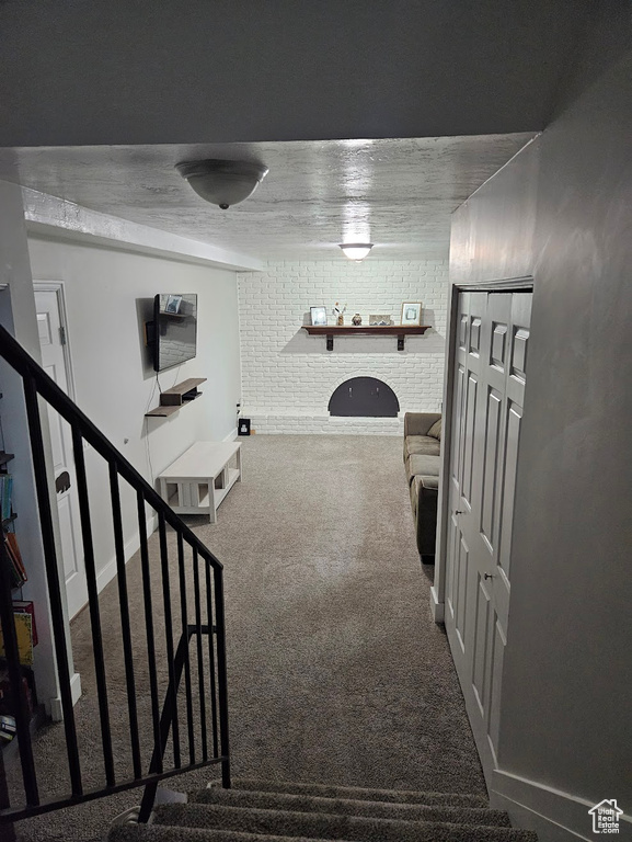 Hall with carpet floors and brick wall