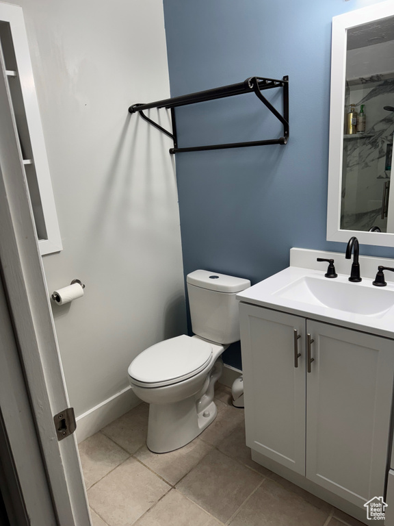 Bathroom with toilet, vanity, and tile patterned floors