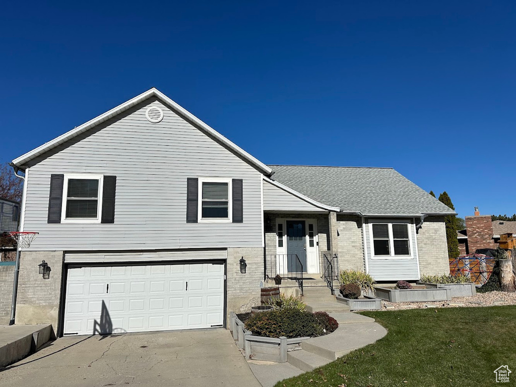 View of front of property featuring a garage and a front yard