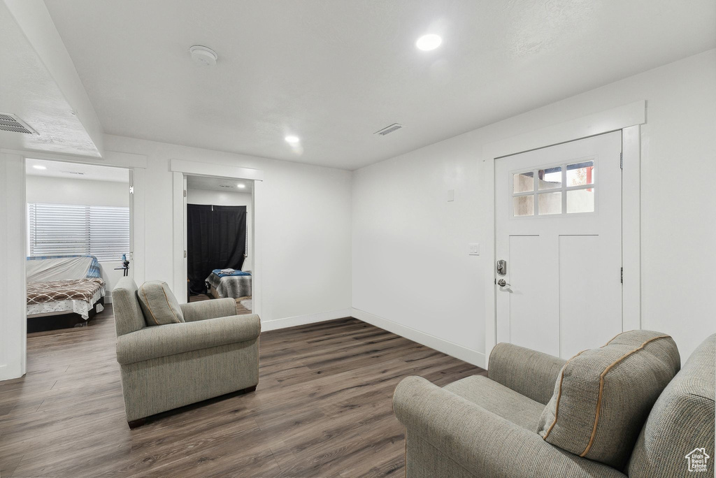 Living room with dark wood-style flooring, baseboards, and recessed lighting