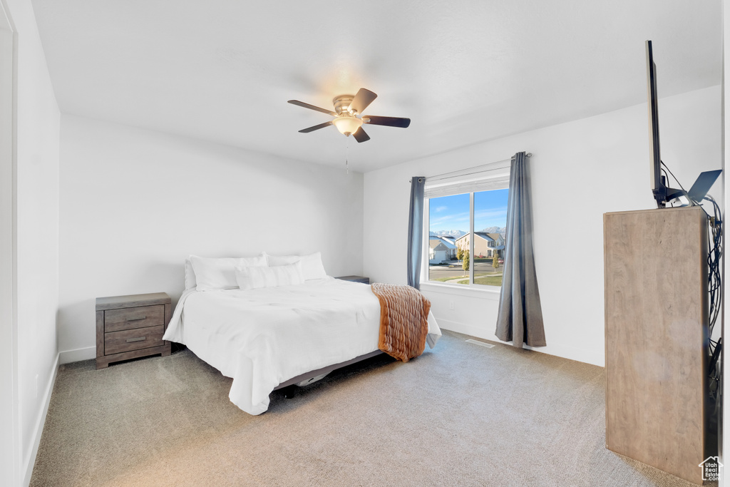 Carpeted bedroom featuring ceiling fan