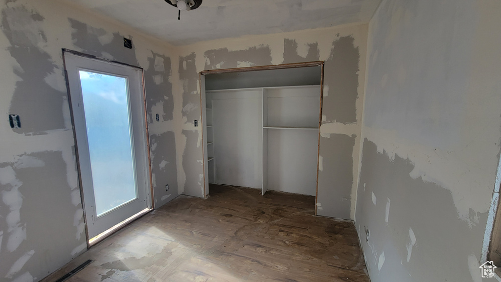 Unfurnished bedroom featuring multiple windows and a closet