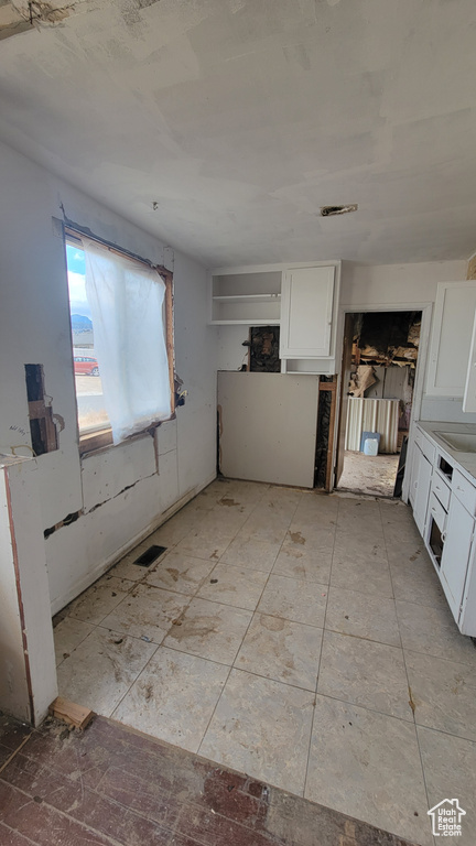 Kitchen featuring white cabinetry and sink