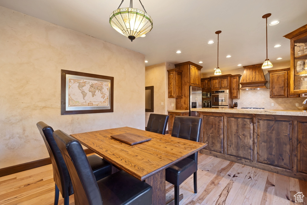 Dining area with light hardwood / wood-style flooring