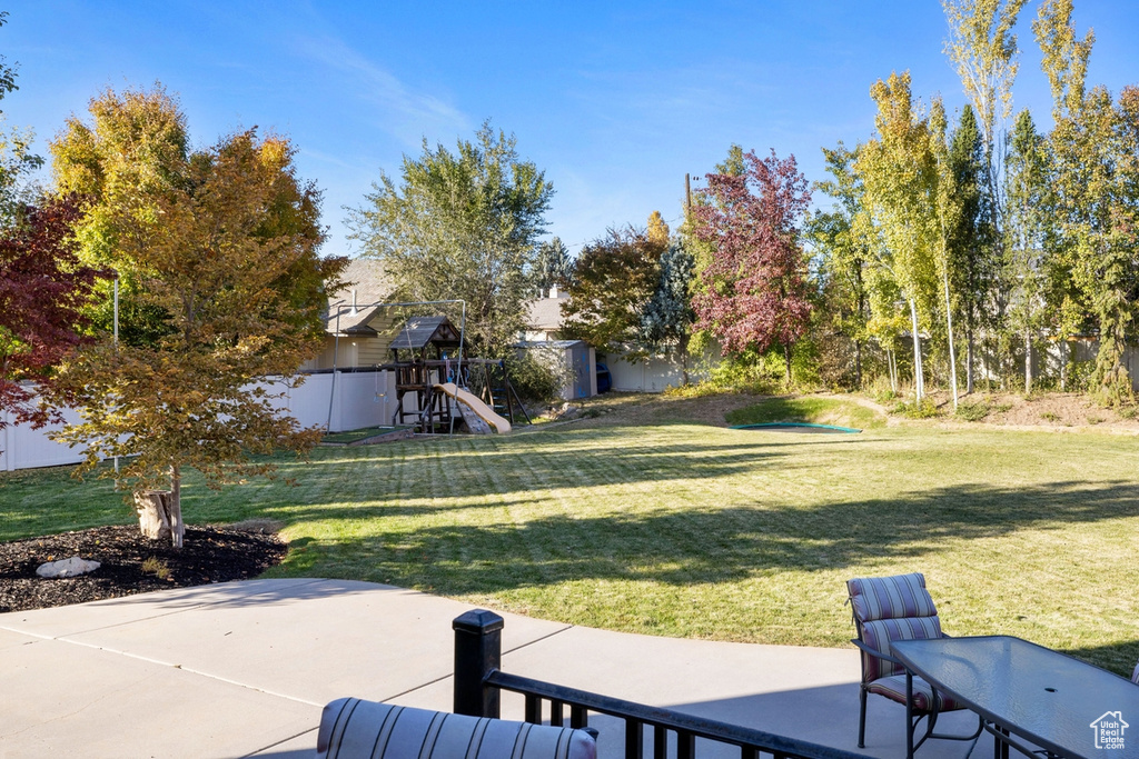 View of yard with a playground and a patio area