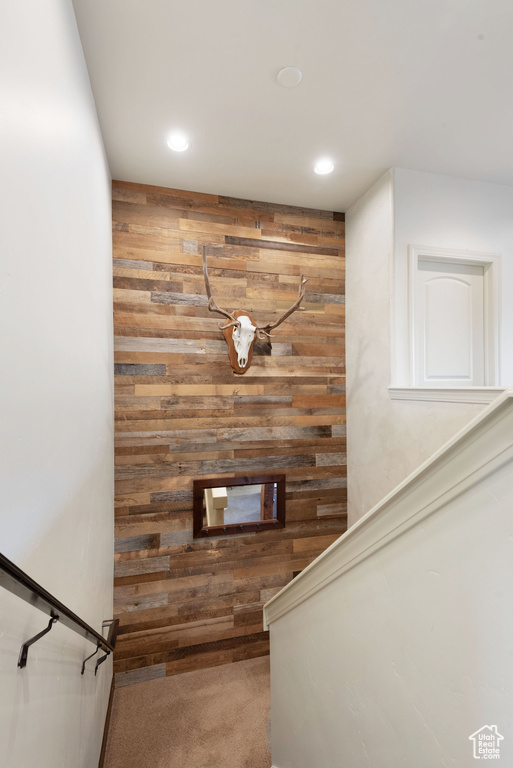 Stairs featuring wood walls and carpet floors