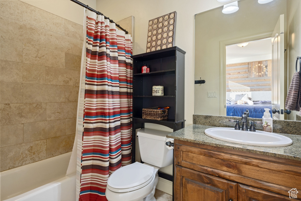 Full bathroom with vanity, shower / bath combination with curtain, and toilet