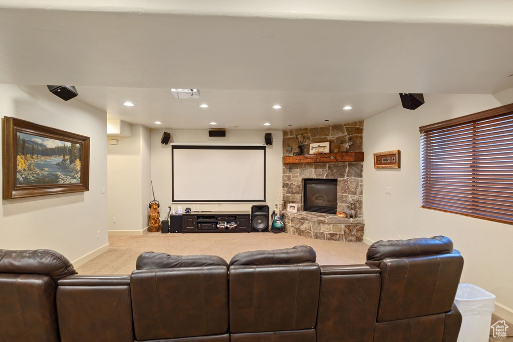 Cinema room featuring a fireplace and light carpet