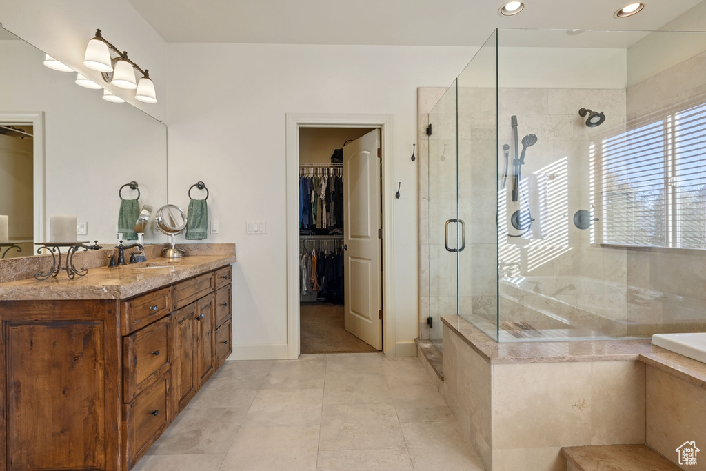 Bathroom featuring walk in shower, vanity, and tile patterned floors
