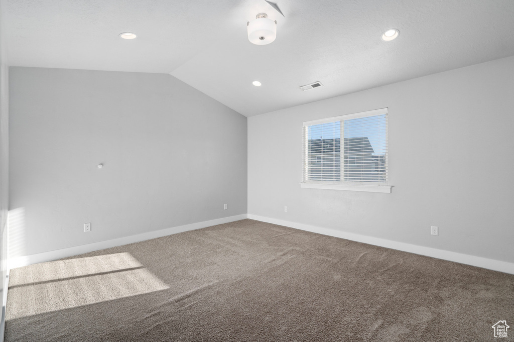 Spare room with lofted ceiling and carpet