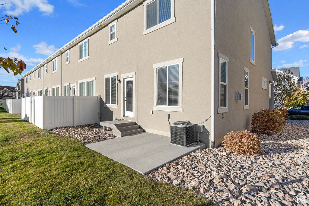 Rear view of property with a yard, central AC, and a patio