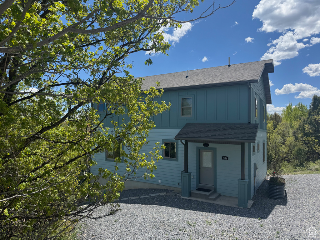 Back of property with board and batten siding and roof with shingles