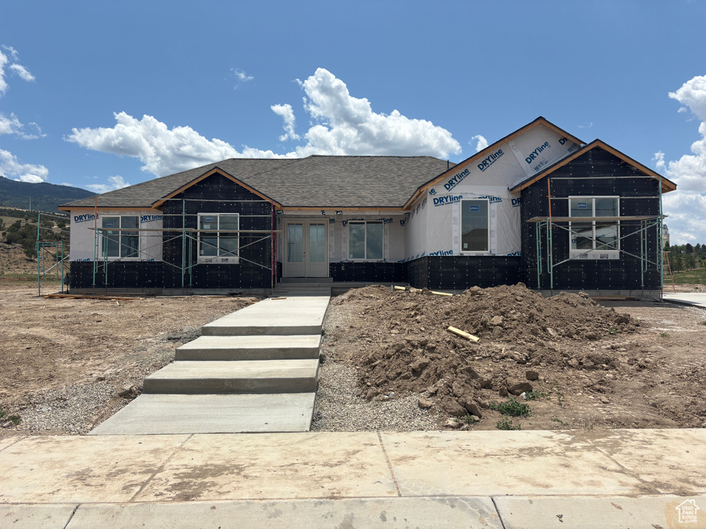 Property under construction with french doors and roof with shingles