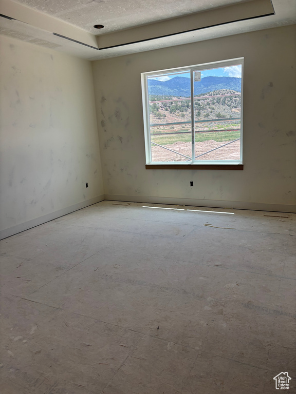 Spare room featuring a raised ceiling and baseboards