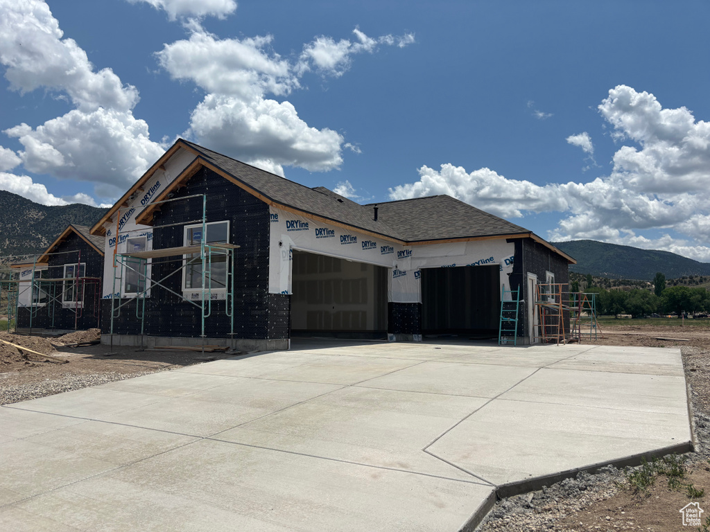 View of front facade with a mountain view, a garage, and driveway