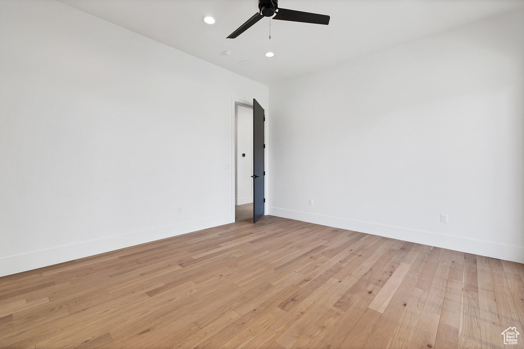 Empty room with light hardwood / wood-style floors and ceiling fan