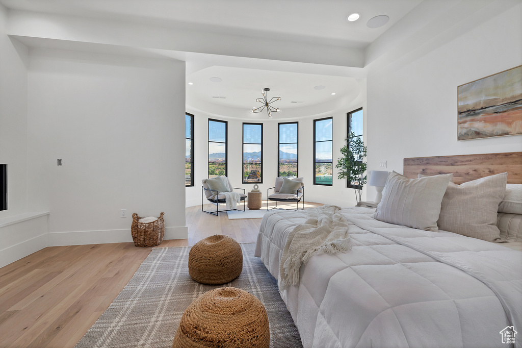 Bedroom featuring light hardwood / wood-style floors and an inviting chandelier