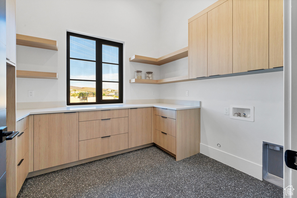 Kitchen with light brown cabinets and built in desk