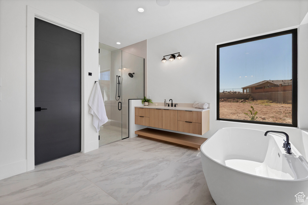 Bathroom featuring vanity and shower with separate bathtub