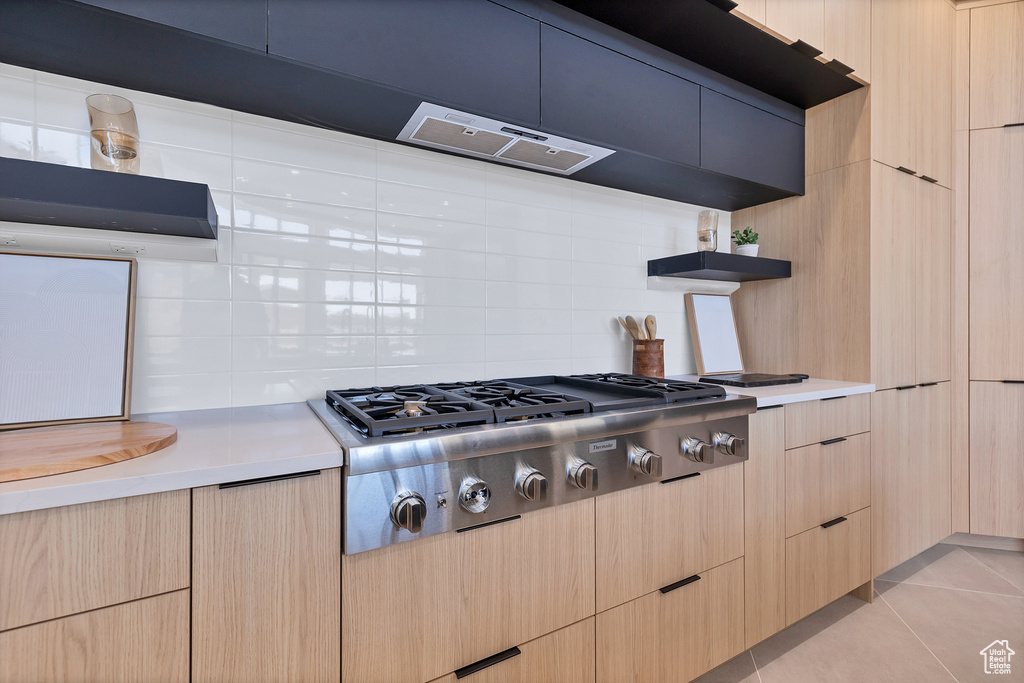 Kitchen featuring backsplash, light brown cabinets, stainless steel gas cooktop, and light tile patterned floors