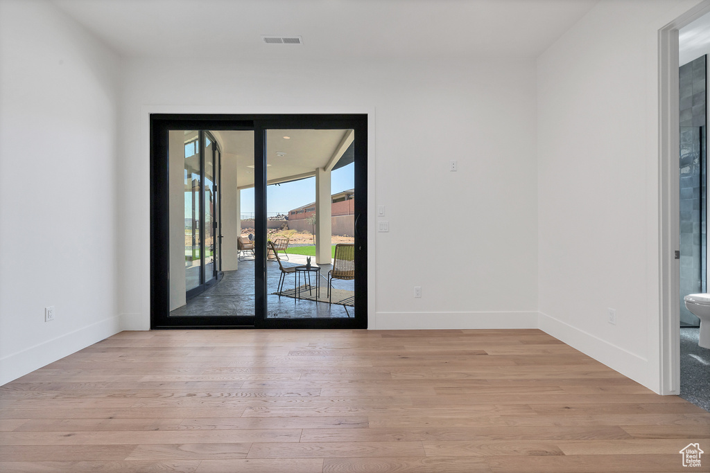 Empty room with light hardwood / wood-style floors