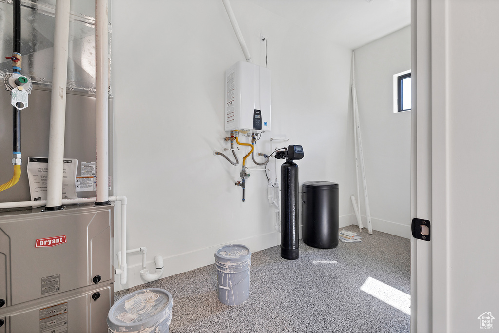 Utility room featuring water heater and heating unit