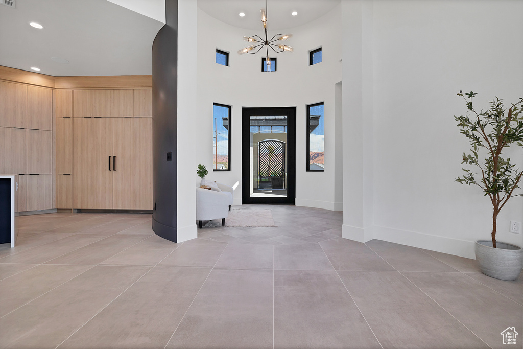 Tiled entryway with a high ceiling and a chandelier