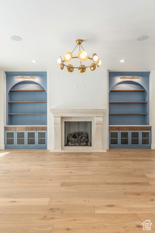 Unfurnished living room featuring hardwood / wood-style flooring and built in shelves